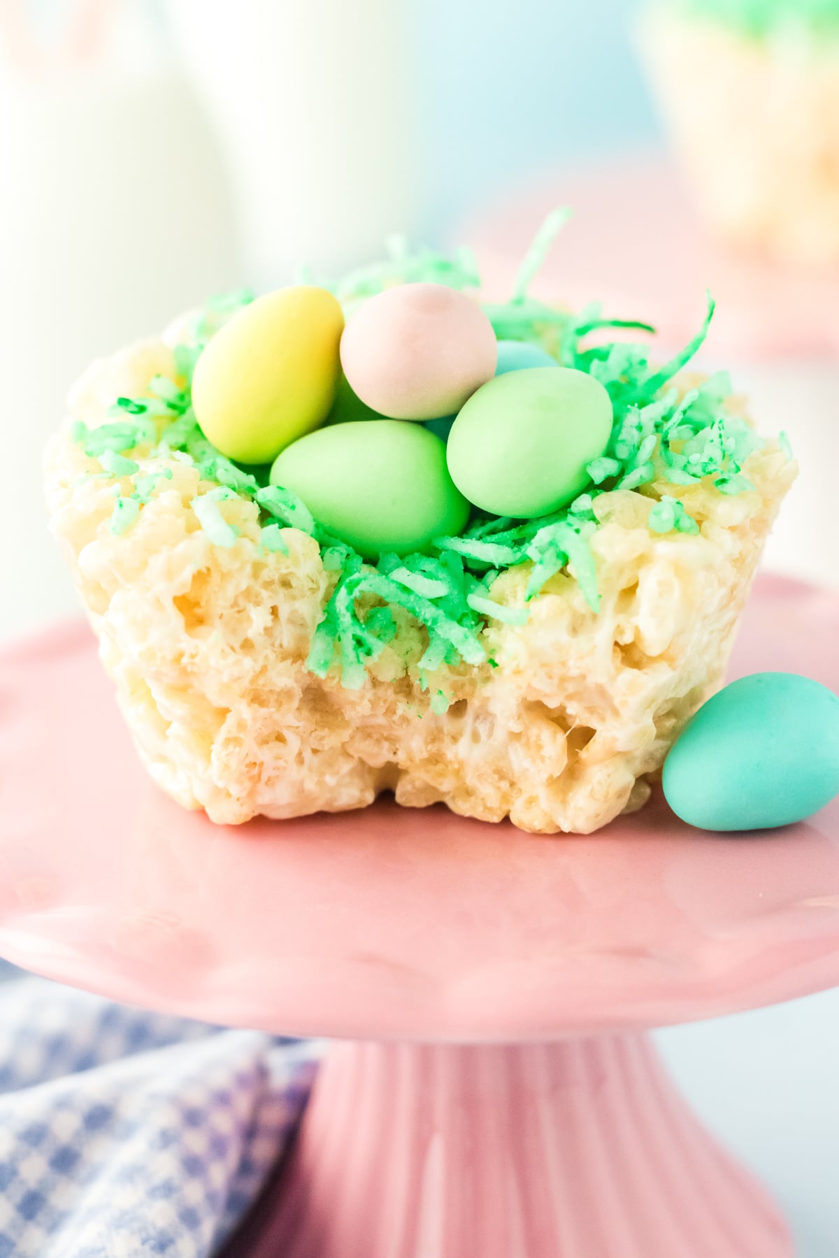 A Rice Krispie Birds Nests on a pedestal missing a bite.