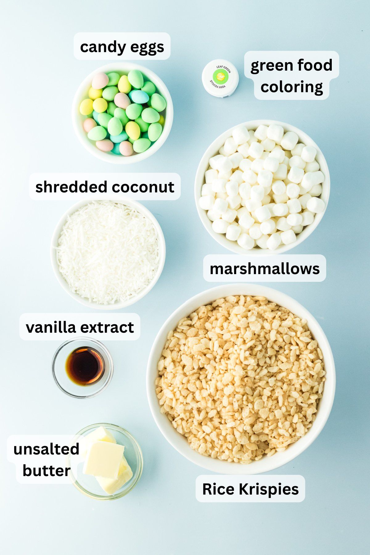 All of the ingredients needed to make Rice Krispie Easter Nests in bowls on a table.