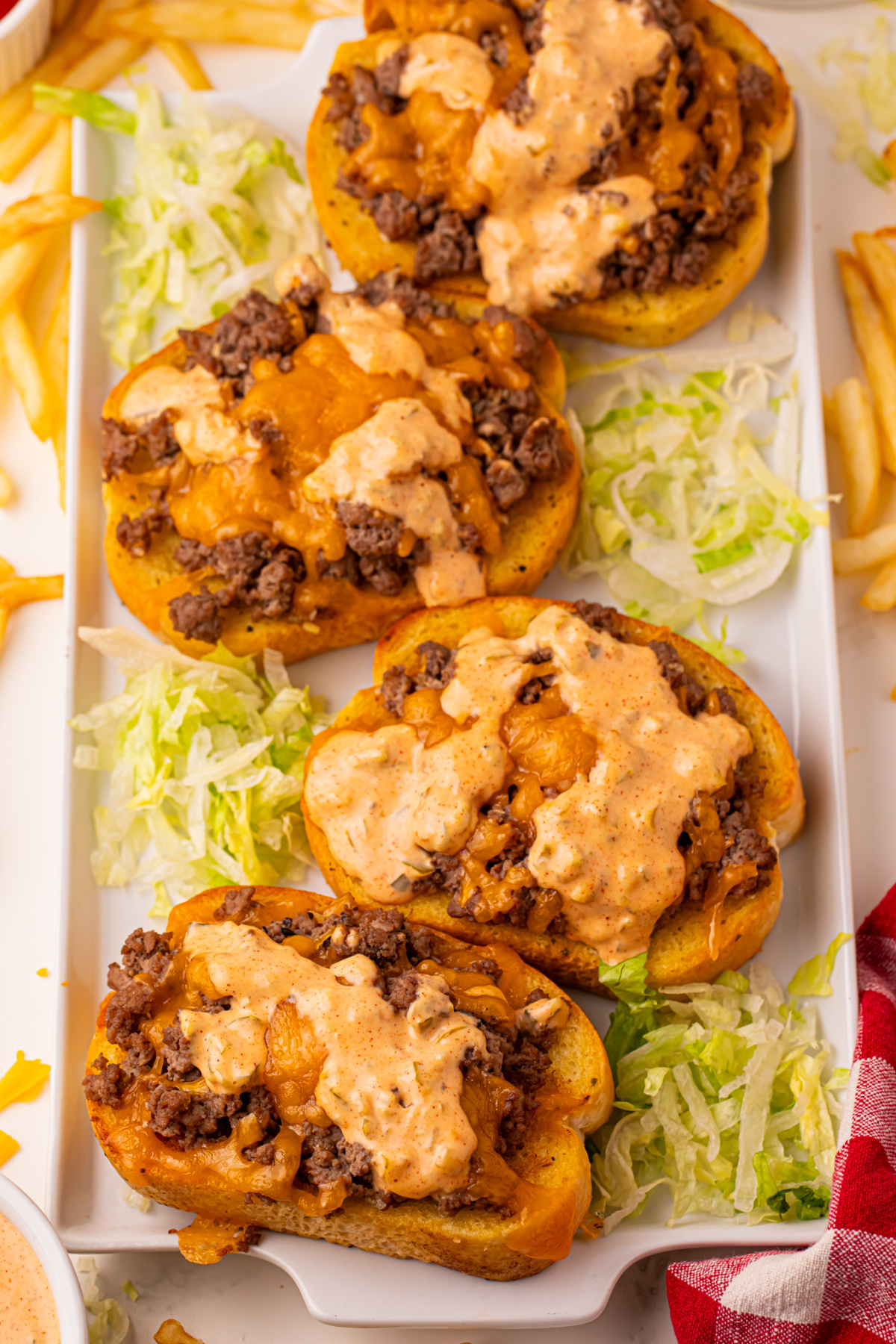 Four open-faced Texas Toast Big Macs. on a platter with shredded lettuce