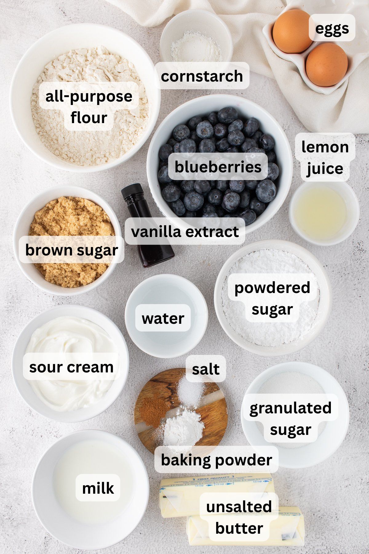 Ingredients to make this blueberry  crumb cake in bowls on a table.