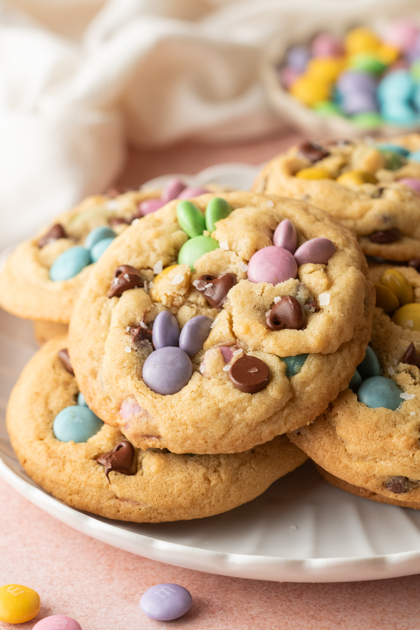 A plate full of cookies with pastel M&Ms and chocolate chips.