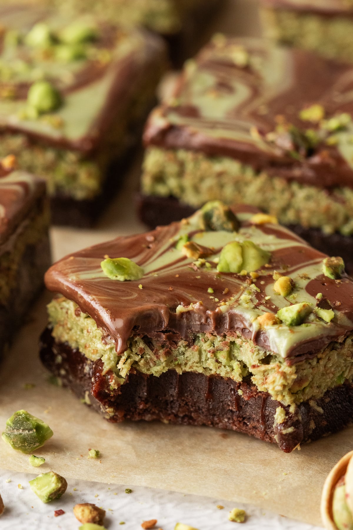 Dubai chocolate brownies on parchment paper with a bite taken.