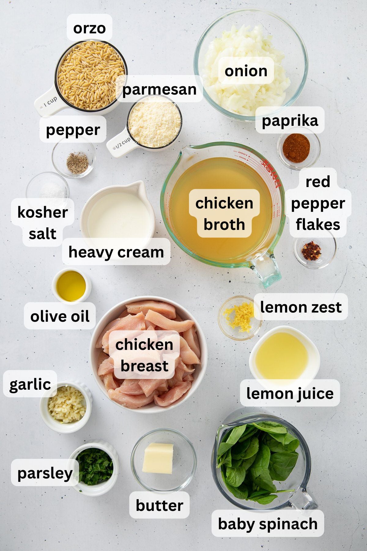 Ingredients to make this chicken and orzo recipe in bowls on a table.
