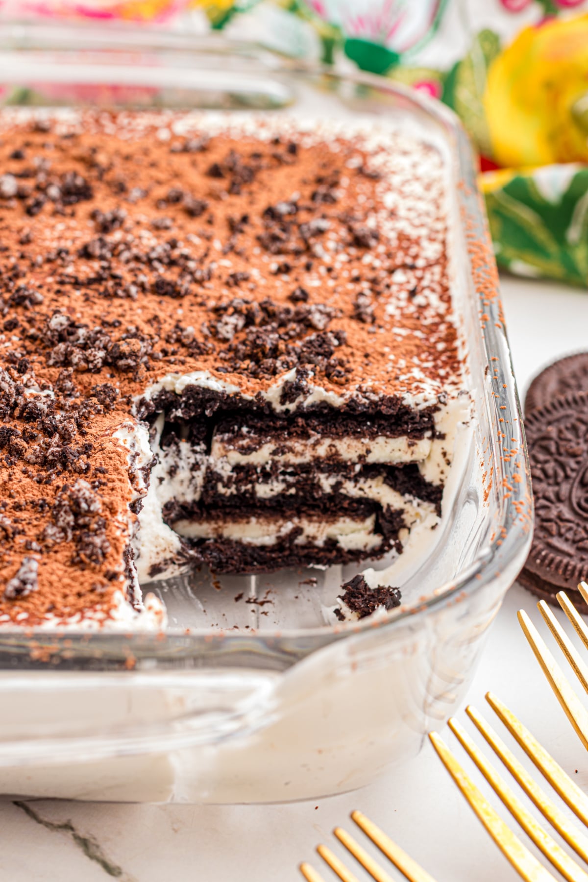 Tiramisu in a glass dish missing a piece.