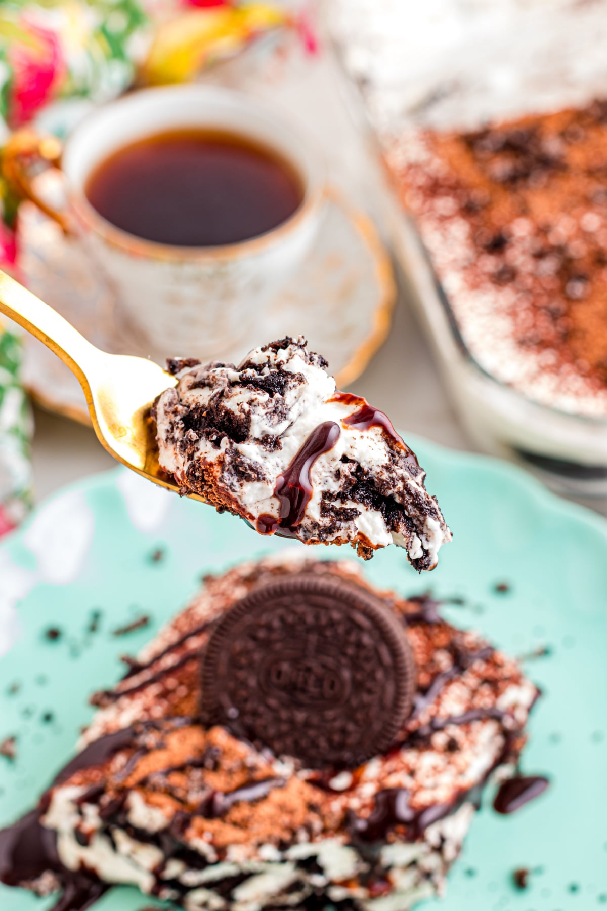 A forkbite of tiramisu held in the air.