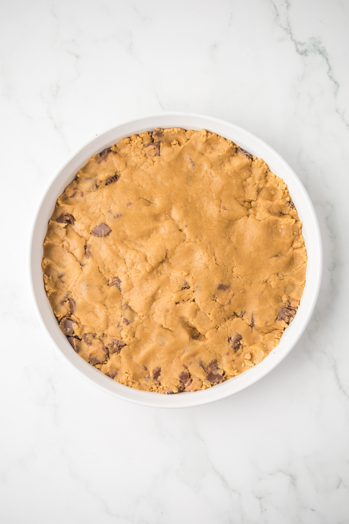 All of the cookie dough pressed into the baking dish.