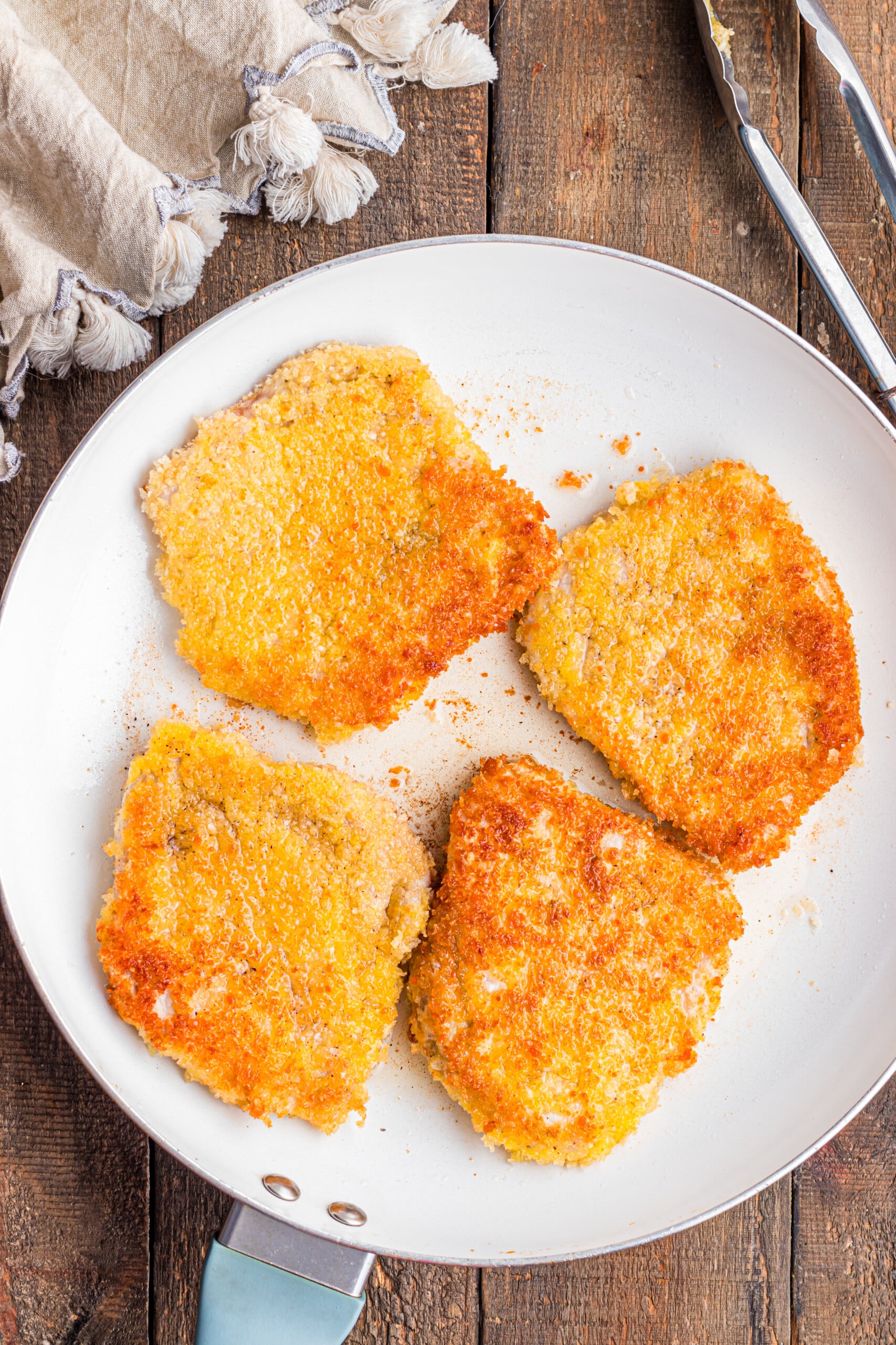 Milanese pork chops that are fried and resting on a plate.