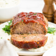 1 pound meatloaf over mashed potatoes on a platter.