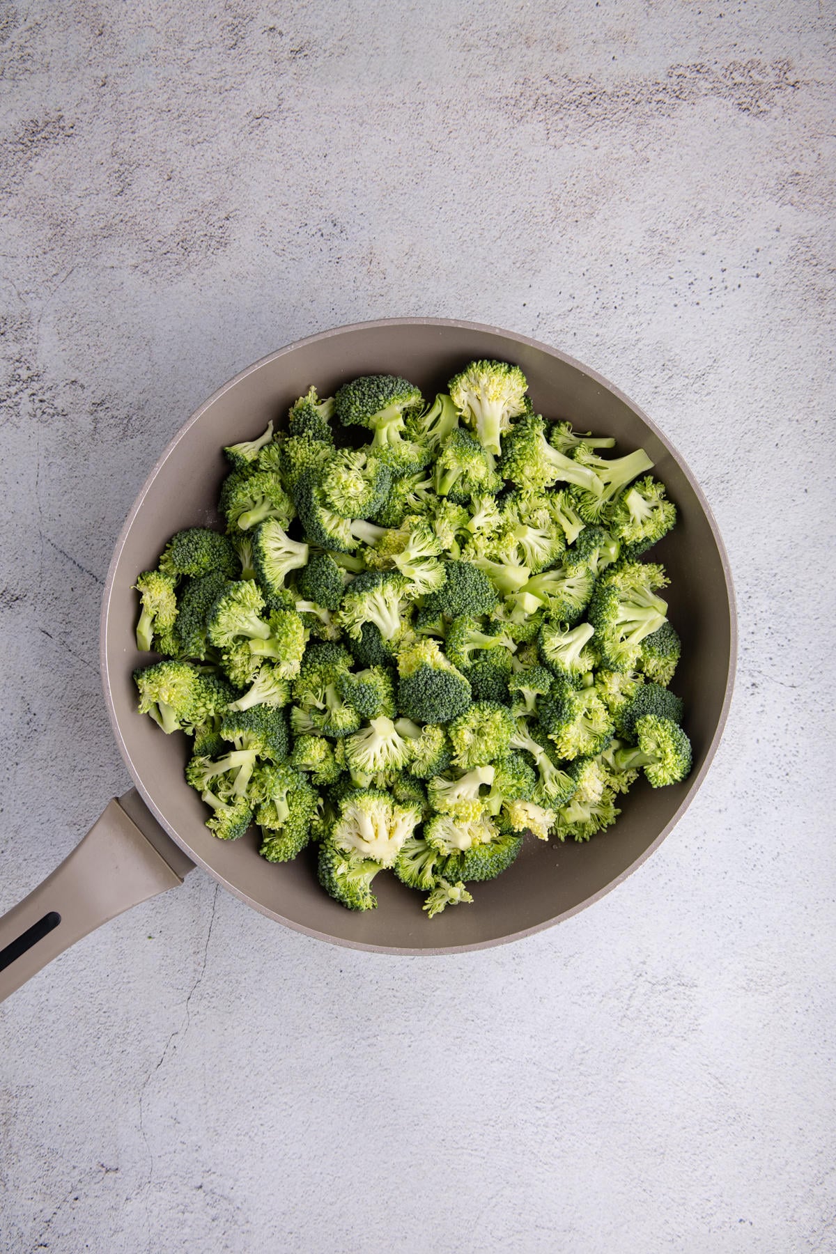 Broccoli florets in a skillet.