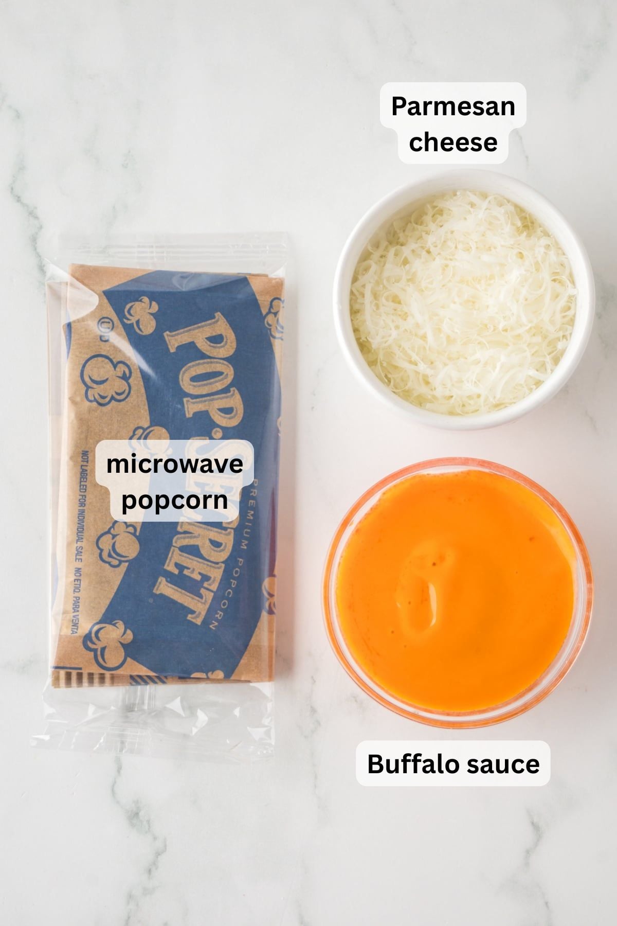 Ingredients to make Buffalo Popcorn in bowls on a table
