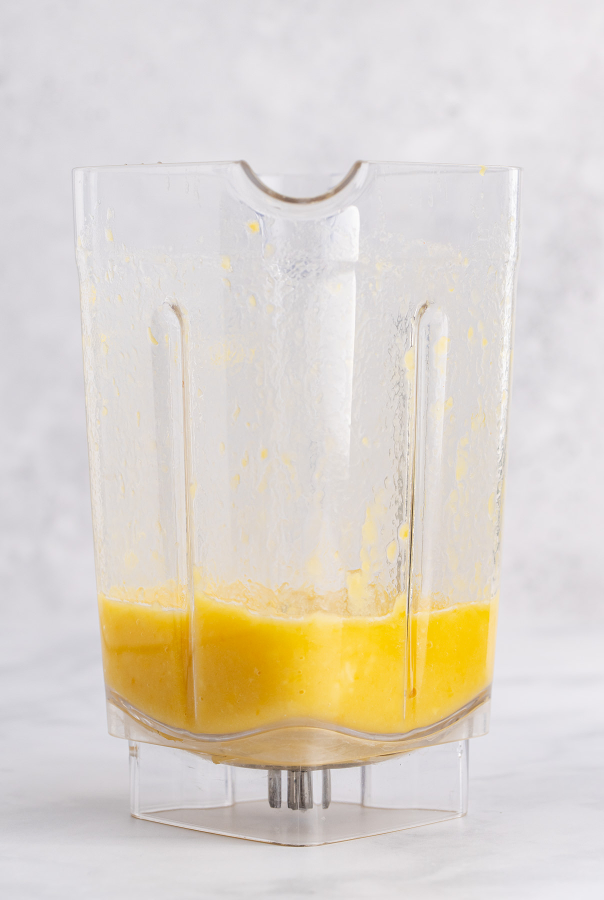 Frozen mango and pineapple juice to a blender.