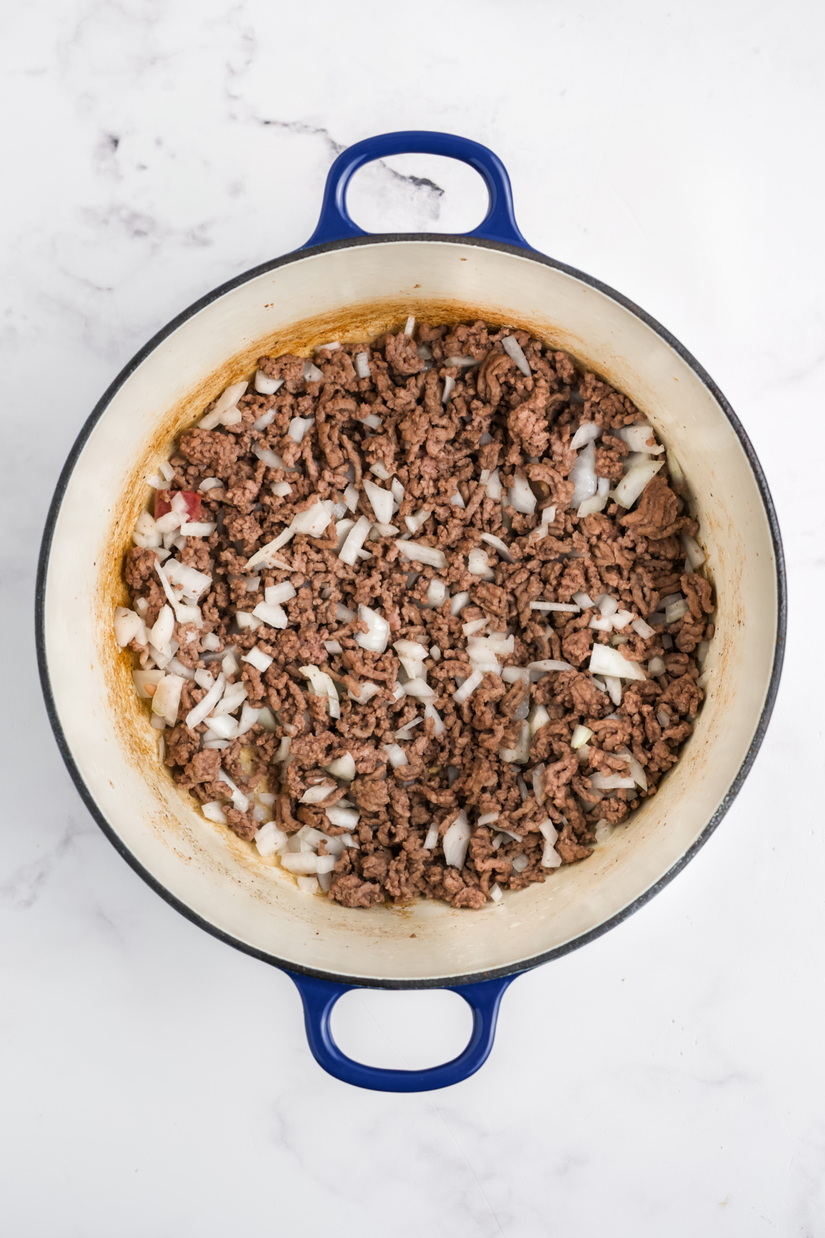 Ground beef, and add the onions and garlic cooking in the pot.