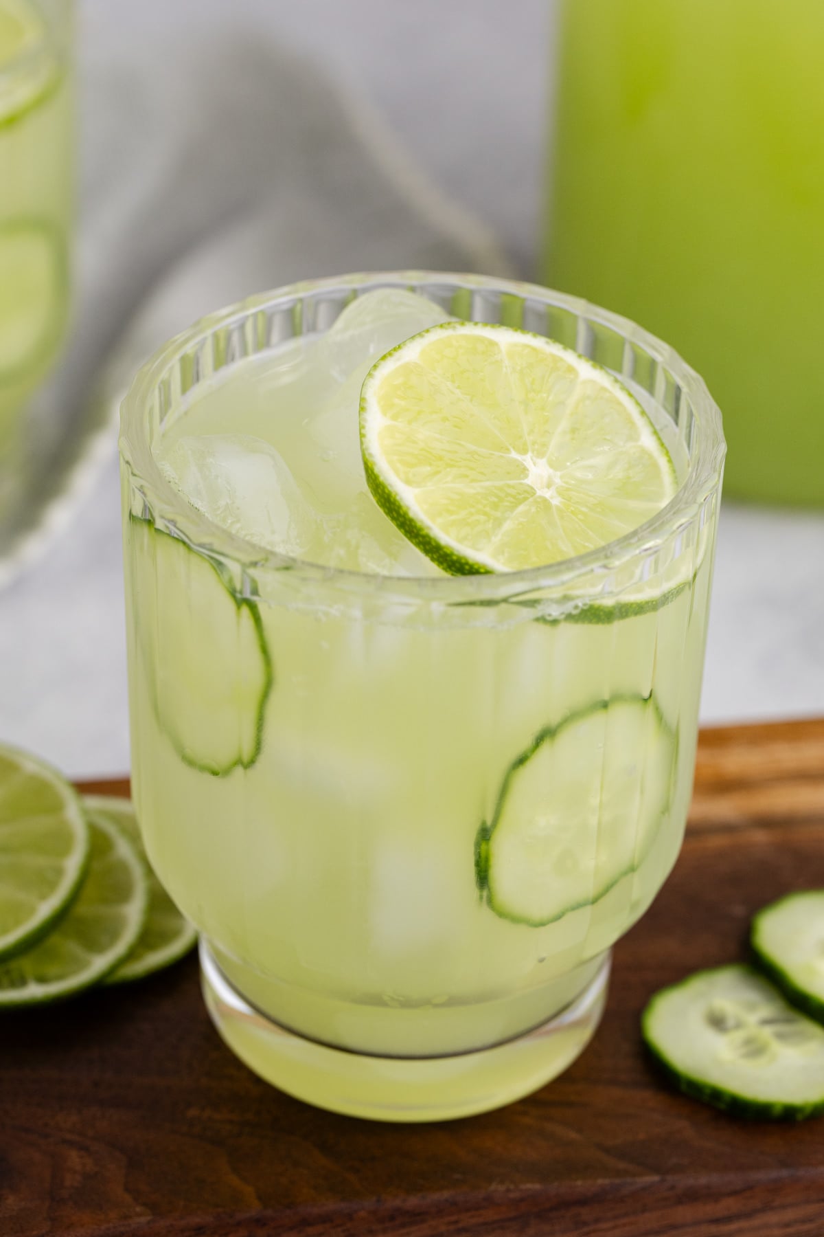Cucumber agua fresca in a glass with a lime on top.