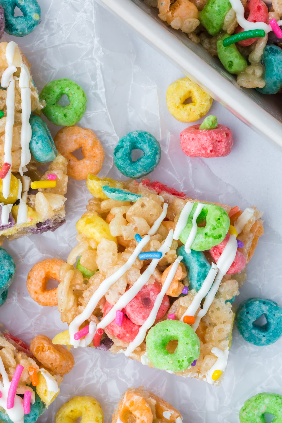 Treats on a counter surrounded by Fruit Loop cereal.