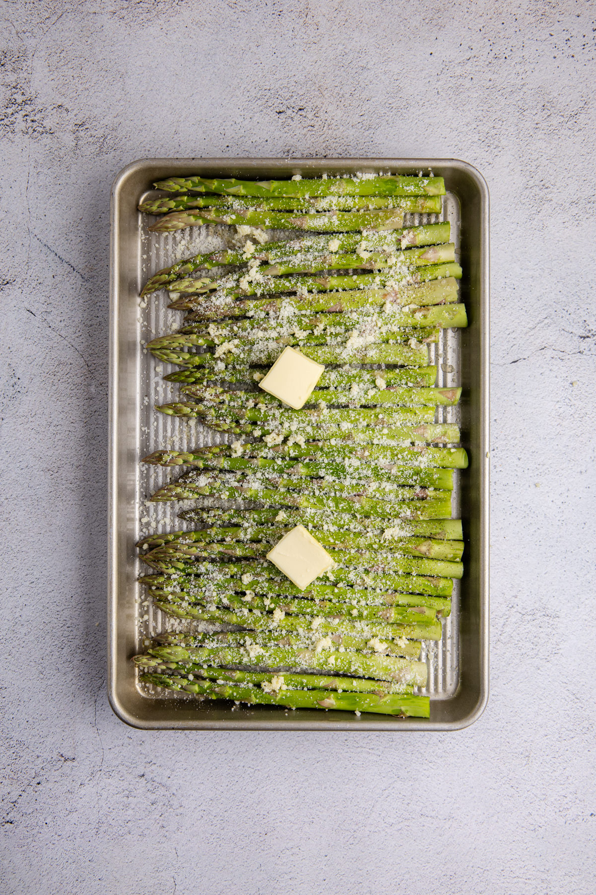 Salt, pepper, olive oil, garlic, lemon juice, and Parmesan cheese on the asparagus.