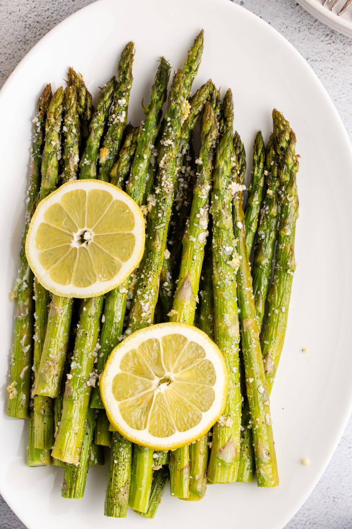 A plate filled with lemon garlic asparagus spears.