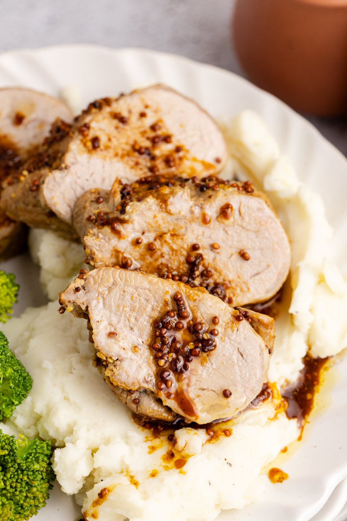Pork tenderloin slices over mashed potatoes.