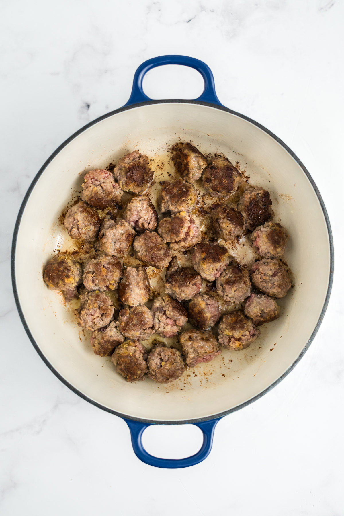 Meatballs browning in a pot.