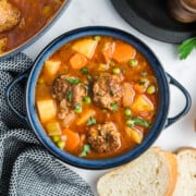 Meatball stew served up in a blue soup crock.