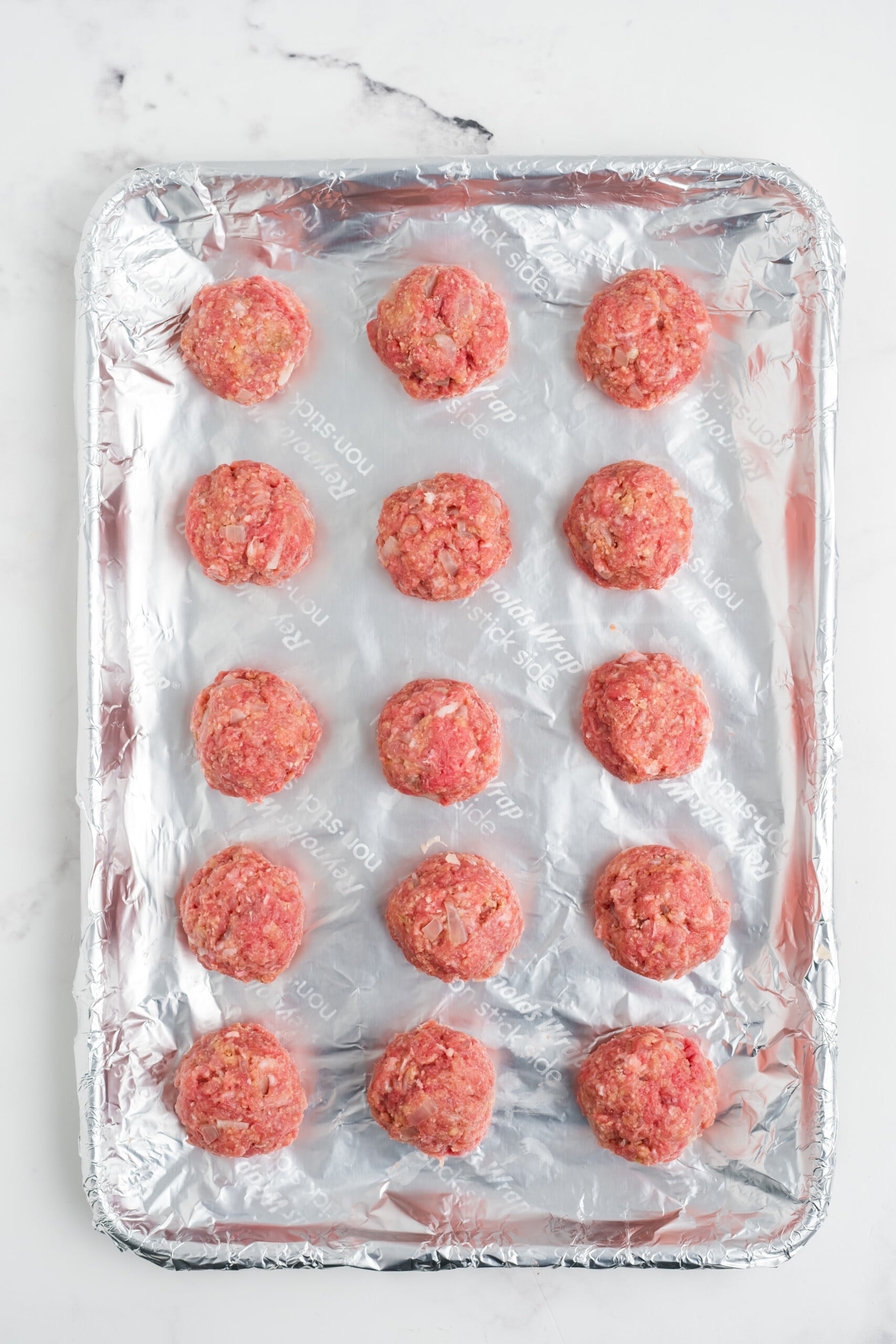 1 &frac12; inch meatballs placed onto the prepared sheet pan.