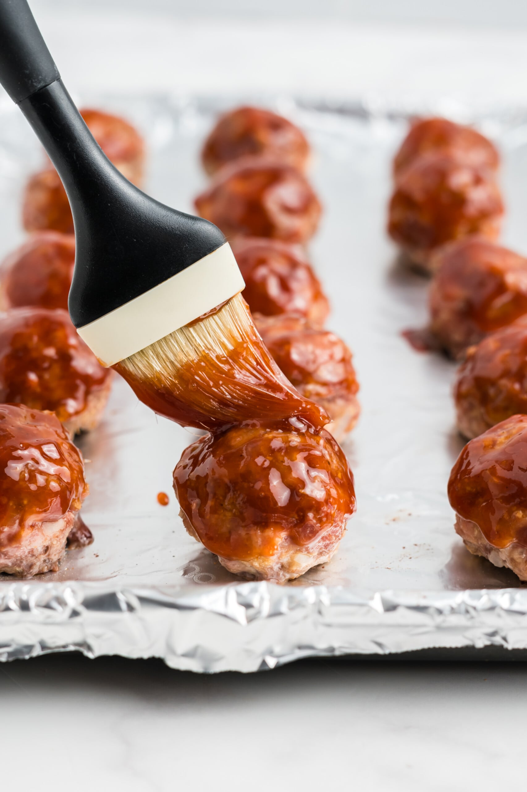 Glaze brushed onto the meatballs.