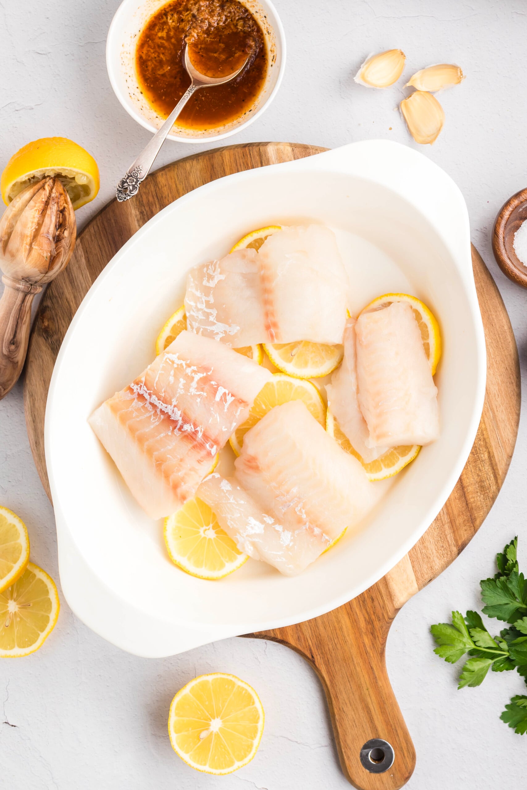 Lemon slices into the bottom of the baking dish and then the haddock filets on top.