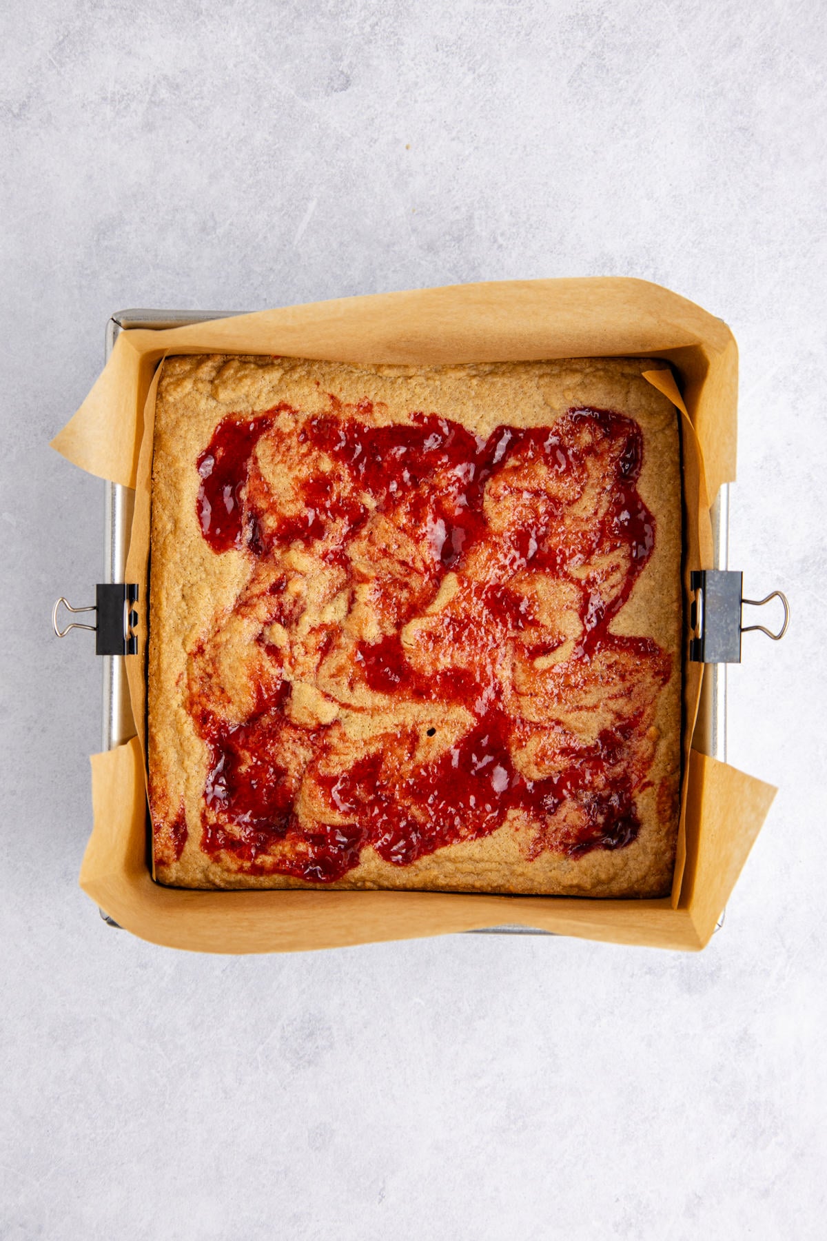 The jelly swirrled on the peanut butter dough.