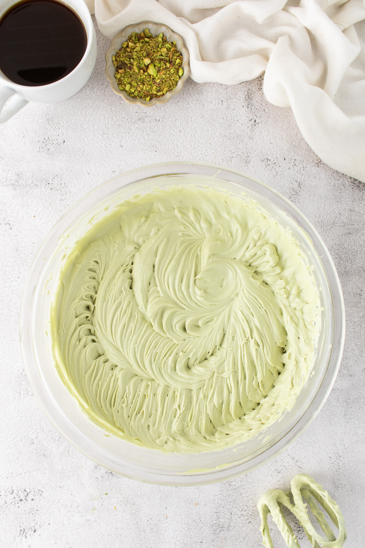 The marscapone, heavy cream, powdered sugar, pistachio cream and vanilla beat together until stiff peaks form.