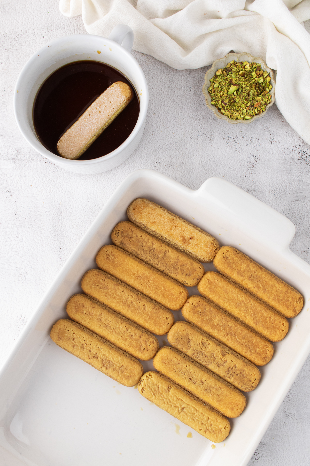 The dipped ladyfingers are placed into the dish.