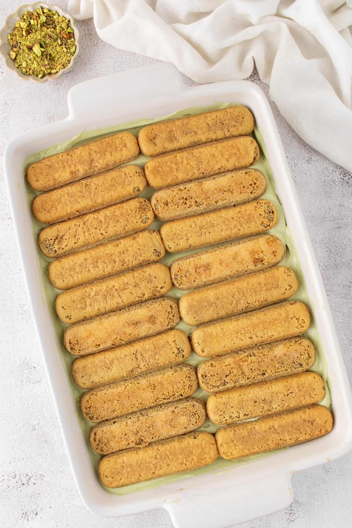 Ladyfingers are added on top of the cream mixture.