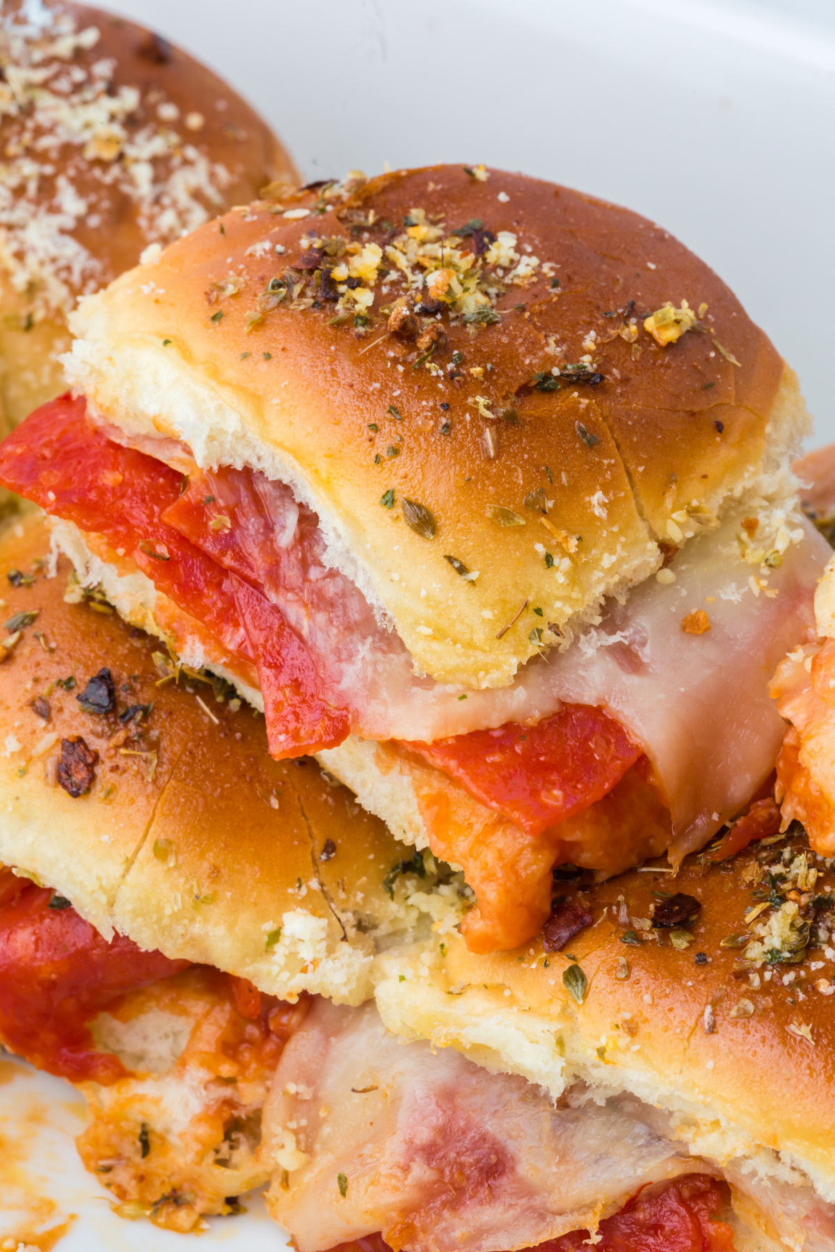 Pizza Sliders in a pan with a couple on top.
