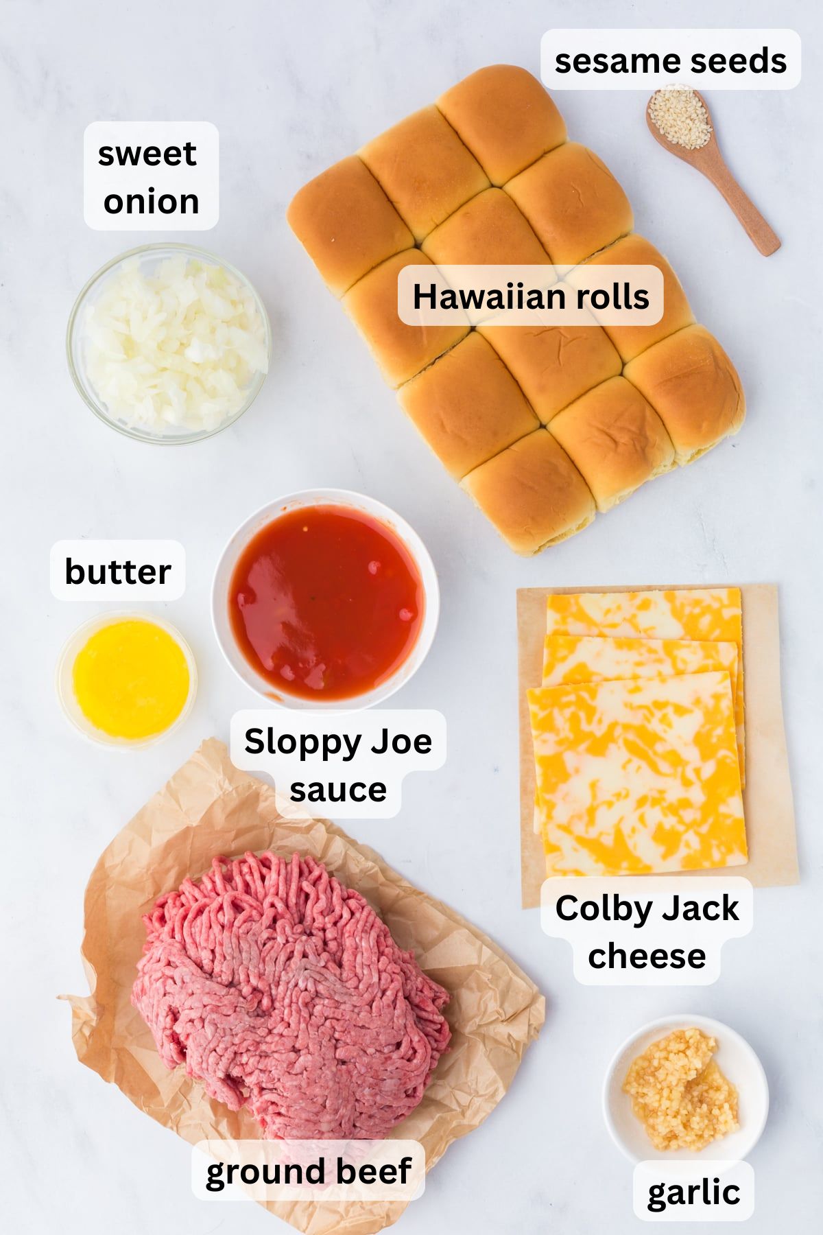 All the ingredients to make Sloppy Joe Sliders in bowls on a table.