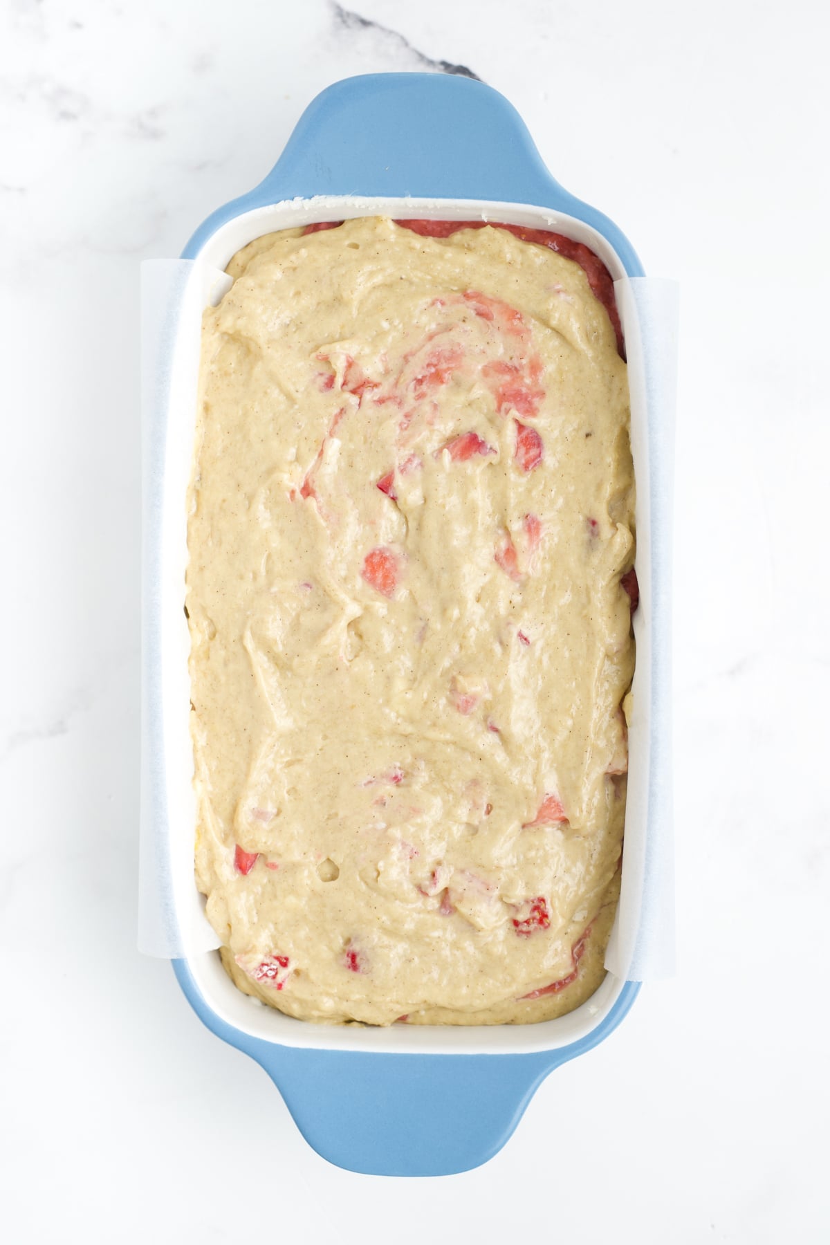 The batter in a loaf pan ready to bake.