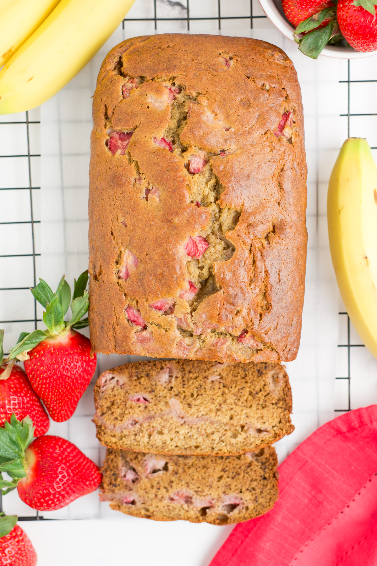 The loaf on a rack with two slices cut.
