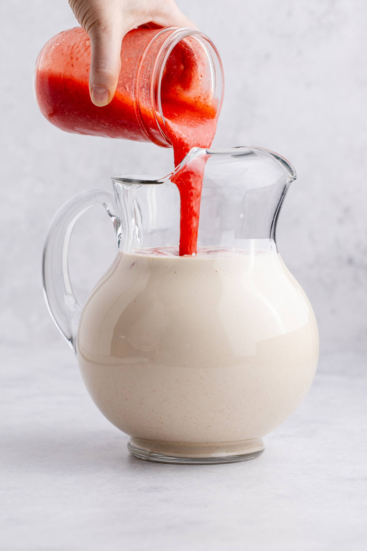 Strawberry puree, evaporated milk, condensed milk, and vanilla poured into the pitcher.