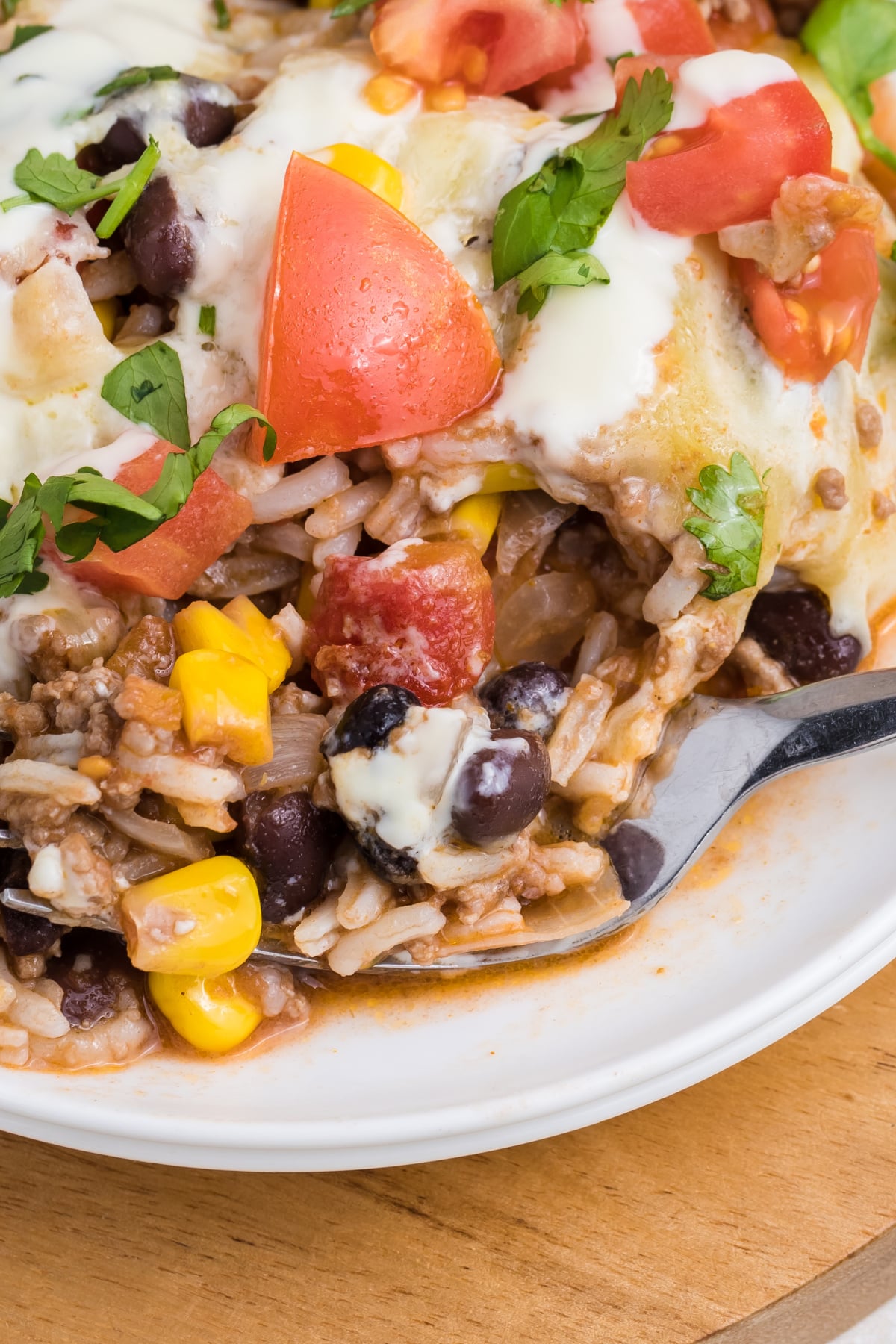 A fork scooping up some casserole with rice.