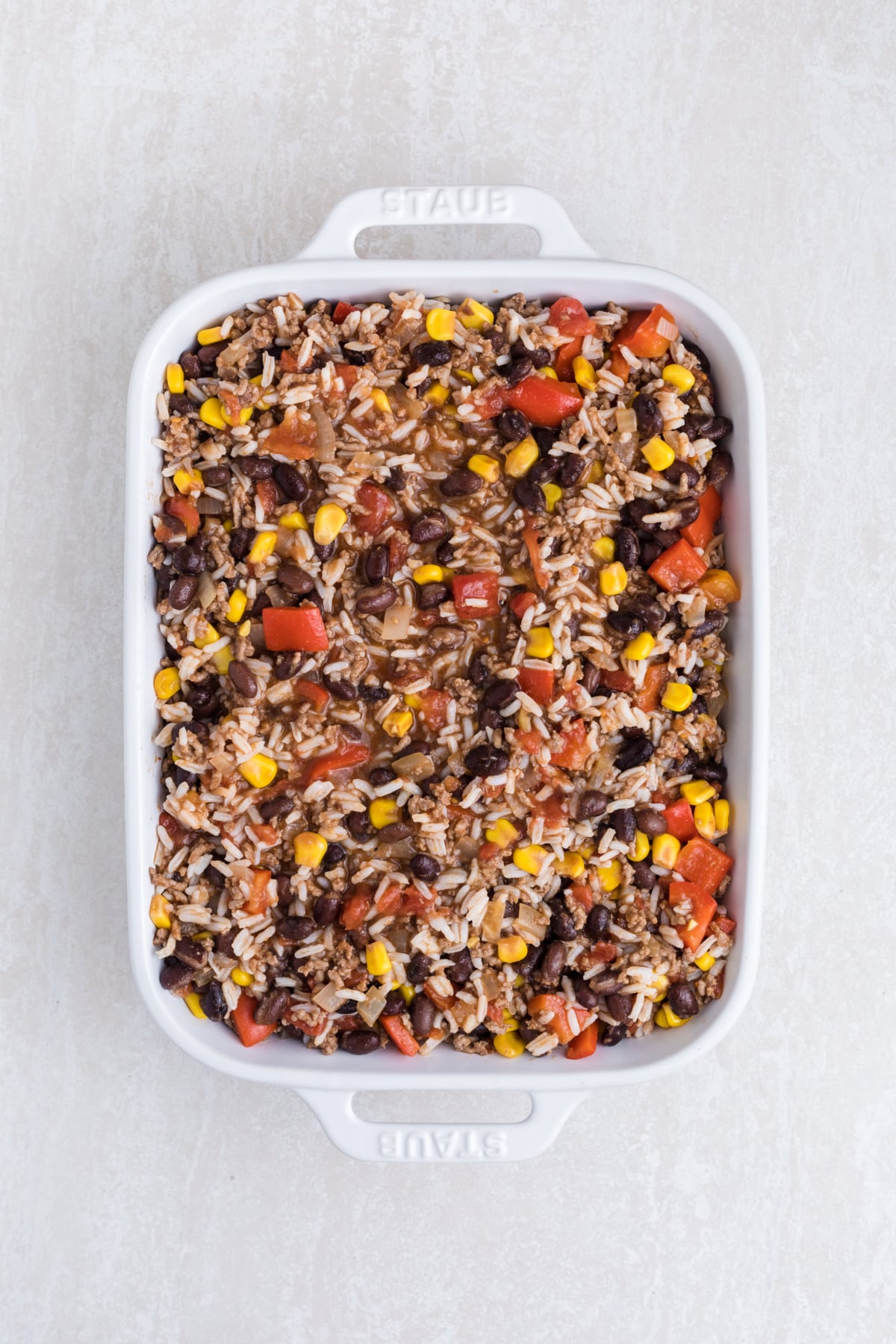 The ground beef mixture added to a casserole dish.