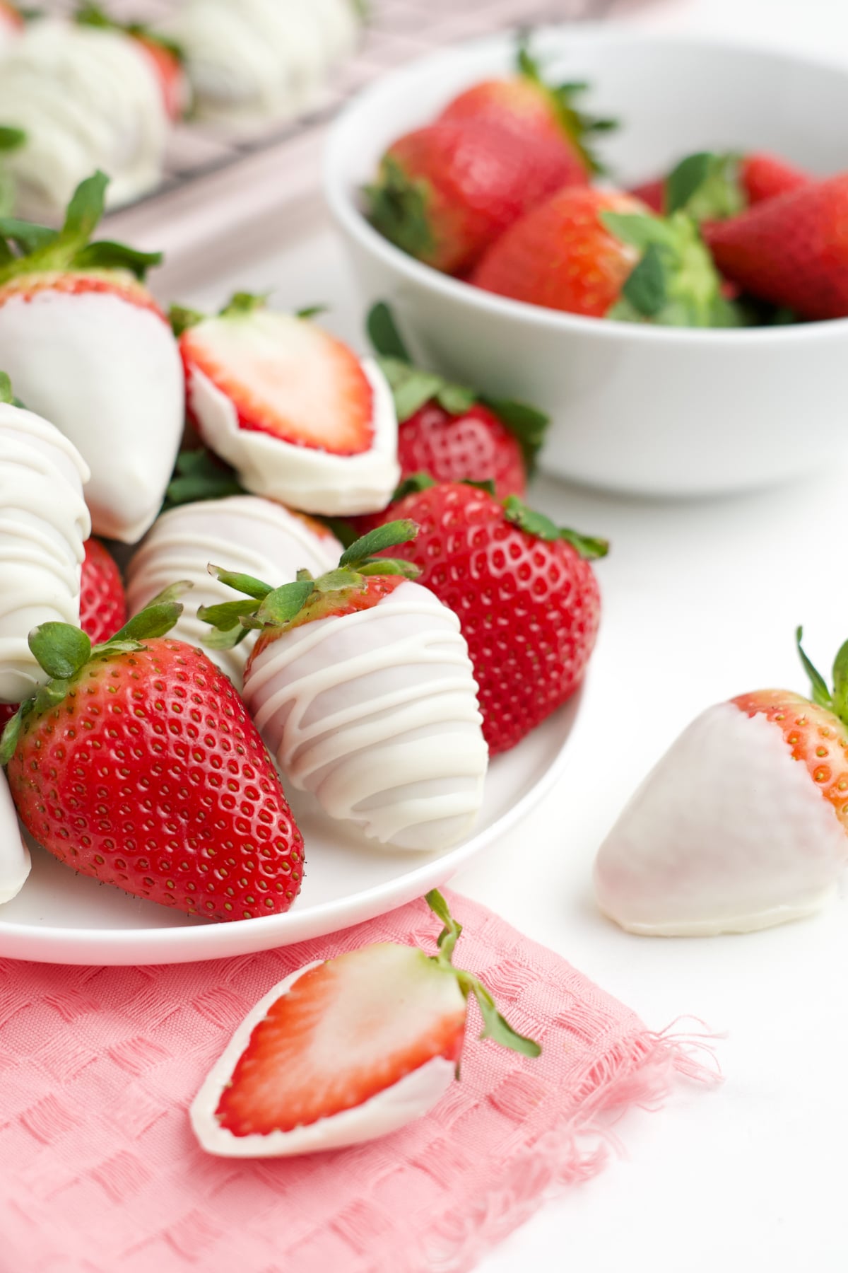 A plate filled with strawberries dipped in white chocolate.