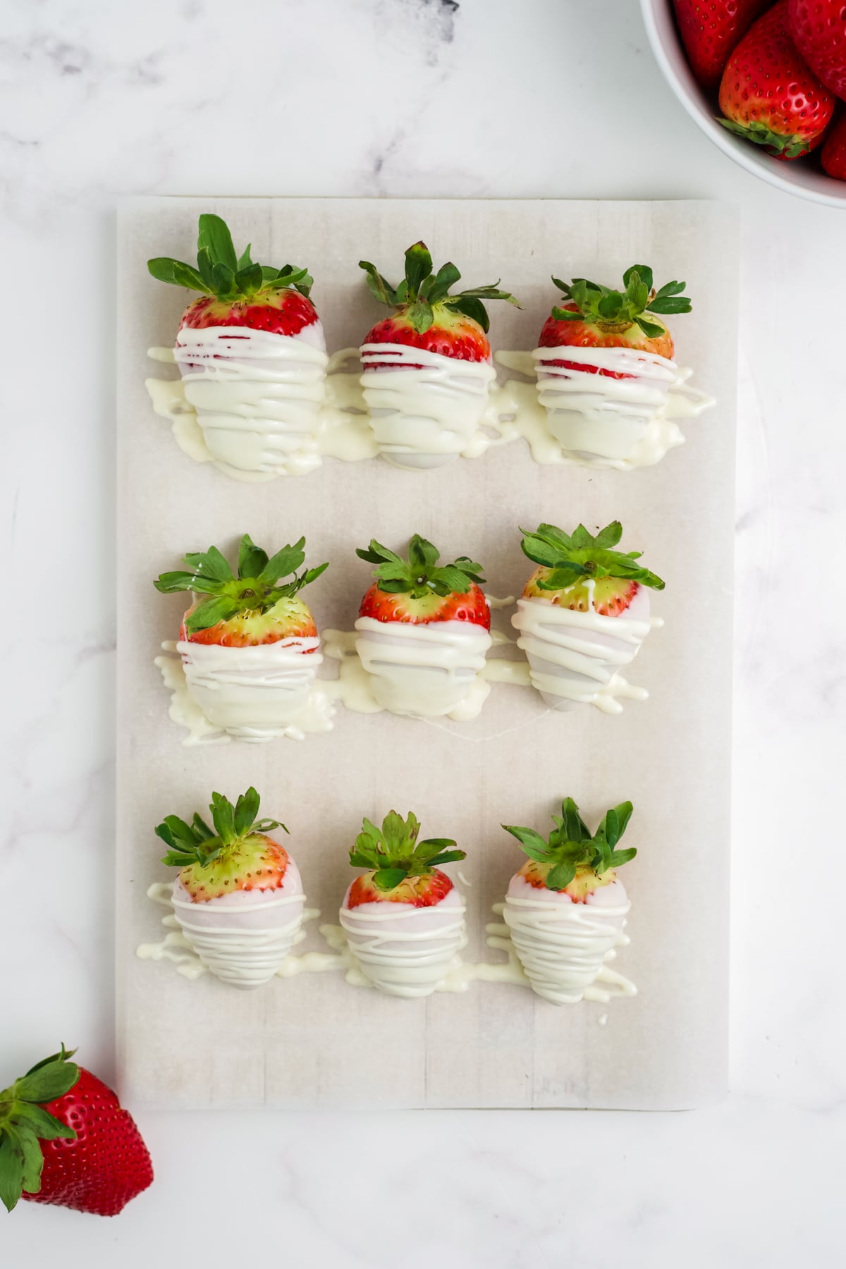 All the strawberries dipped and resting on parchment paper.