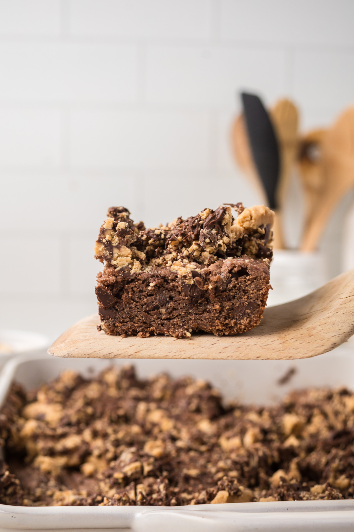 A brownie slice on a spatula held in the air. 