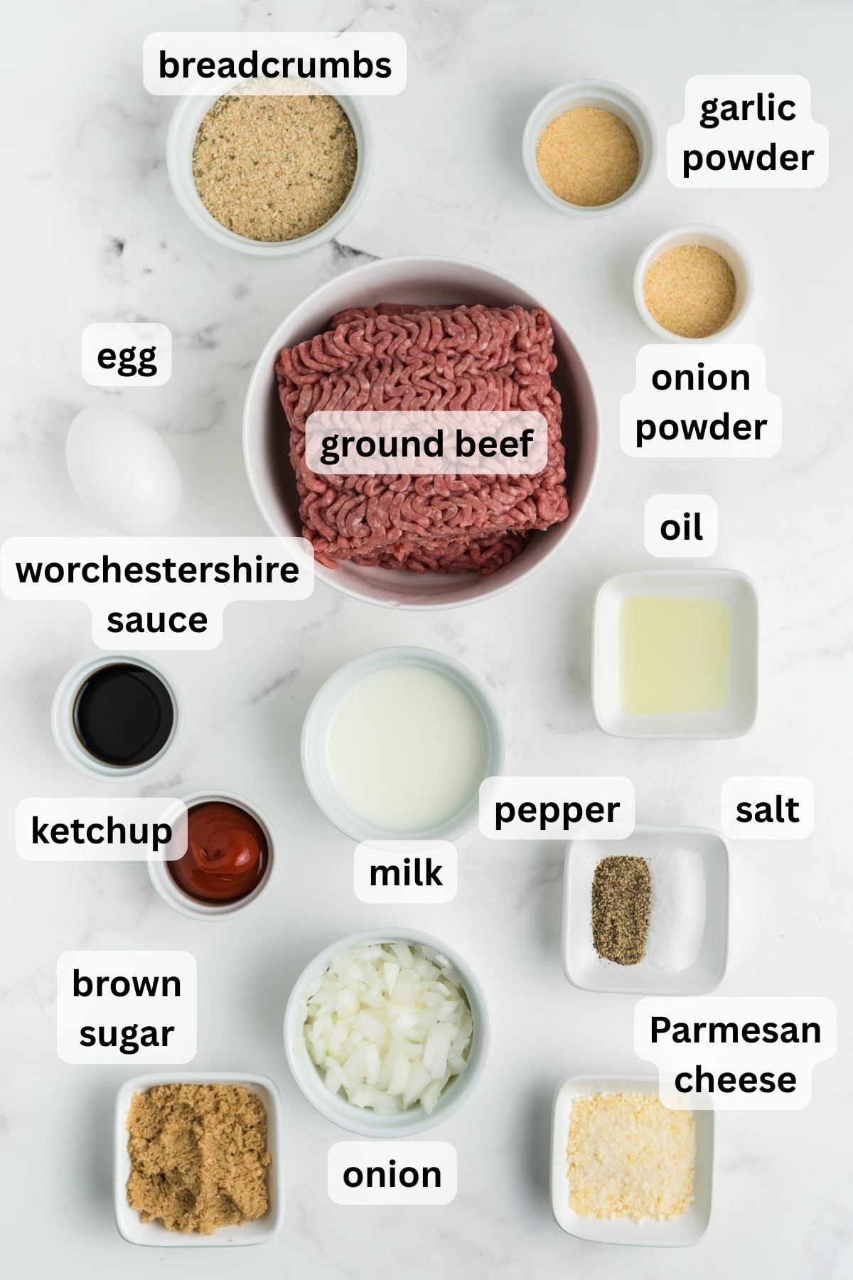 All the ingredients needed to make meatloaf in bowls on a table.