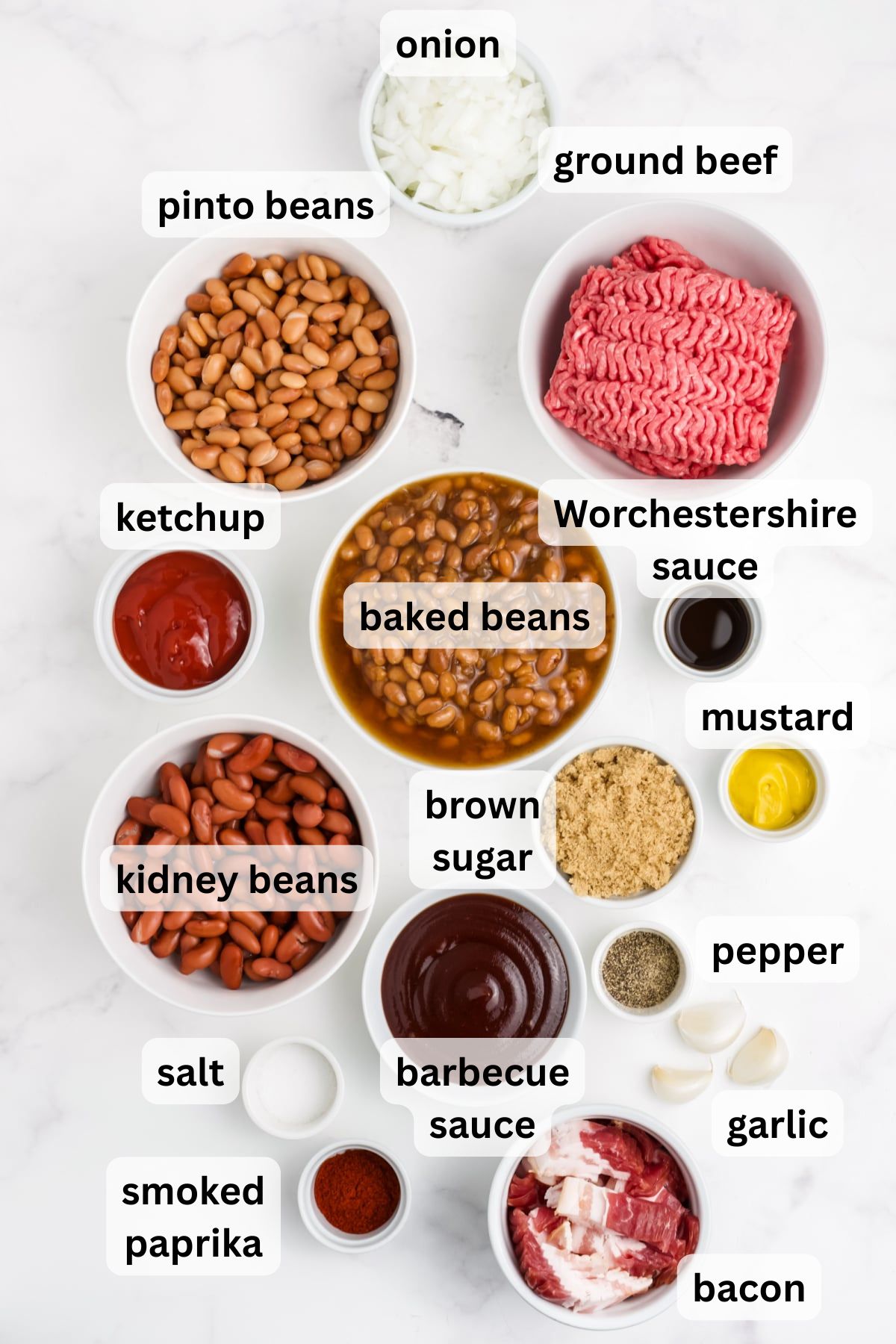 Ingredients to make Cowboy Baked Beans in bowls on a table.