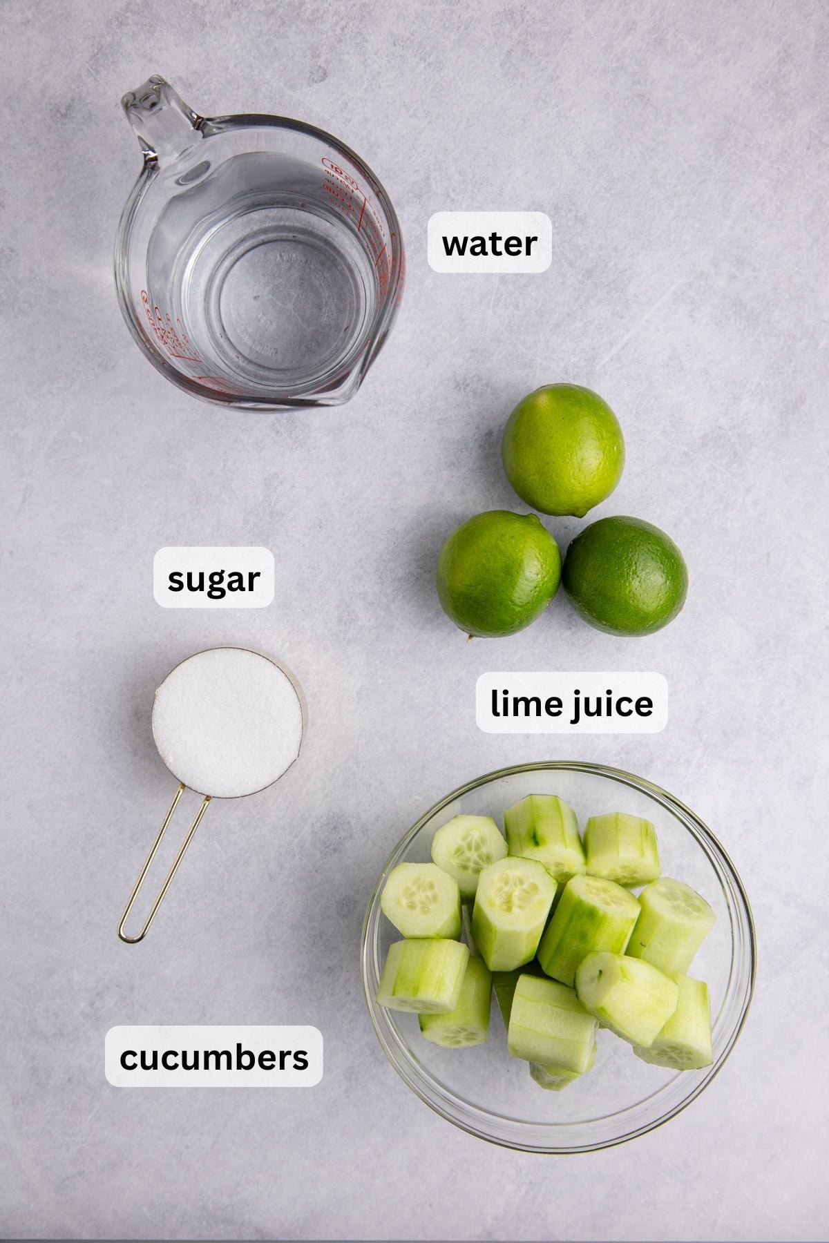 Ingredients needed for Cucumber Agua Fresca in measuring items on a table