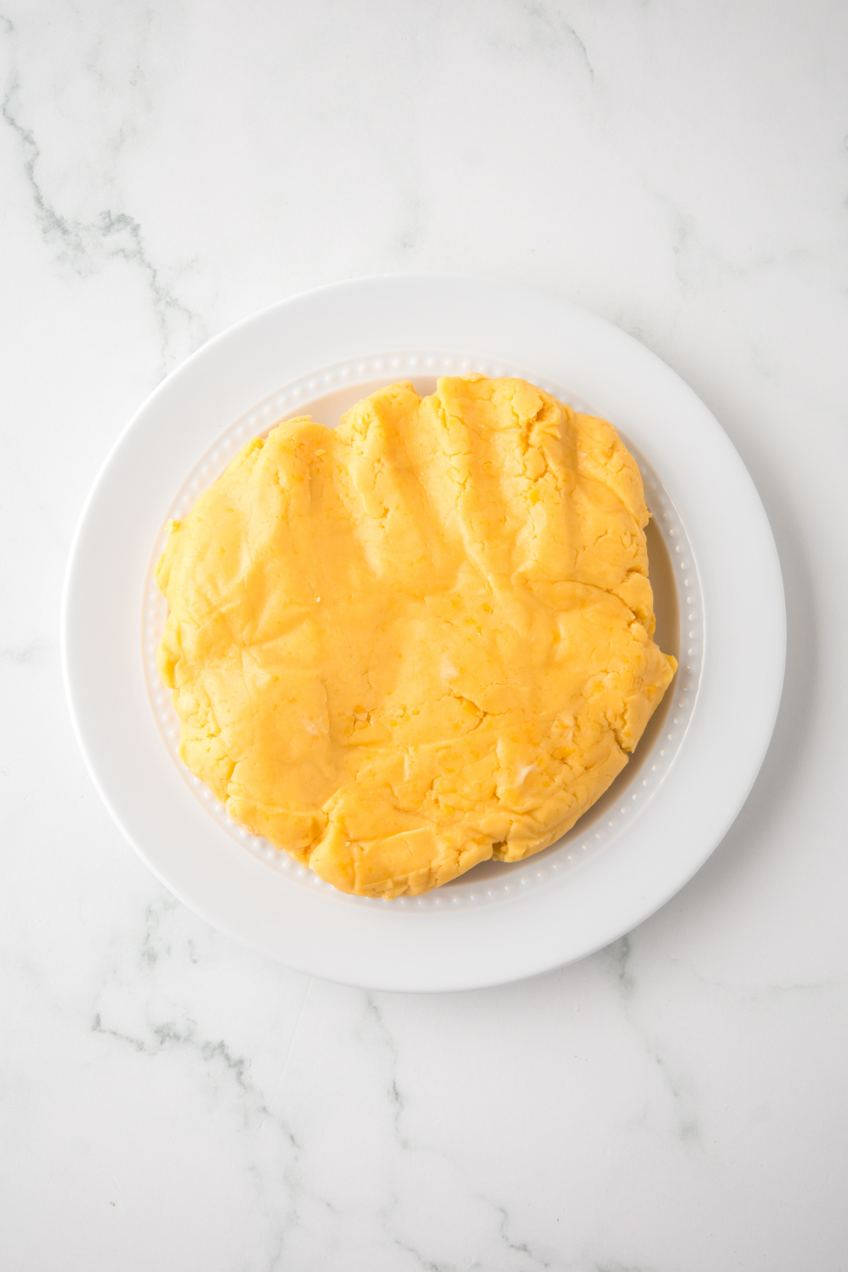 The dough flattened on a plate.