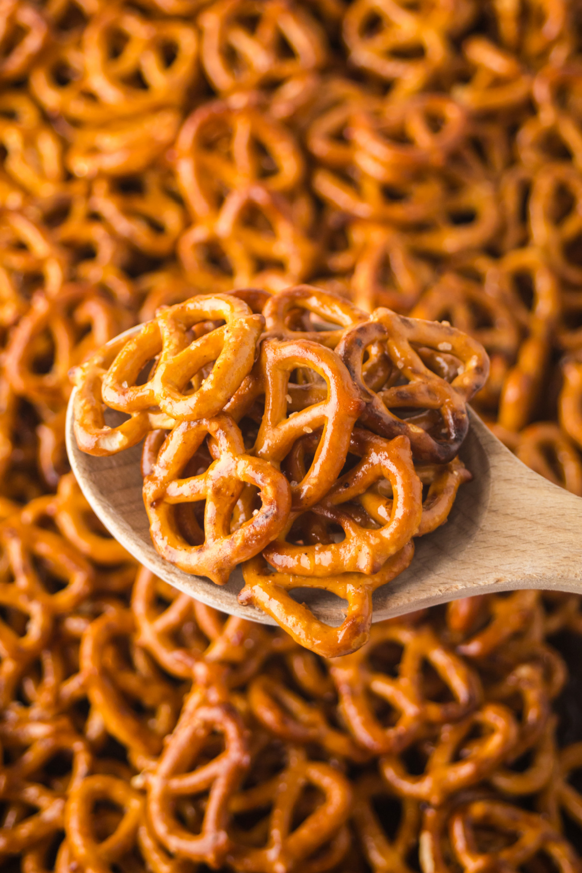 A wooden spoon full of pretzels held in the air.