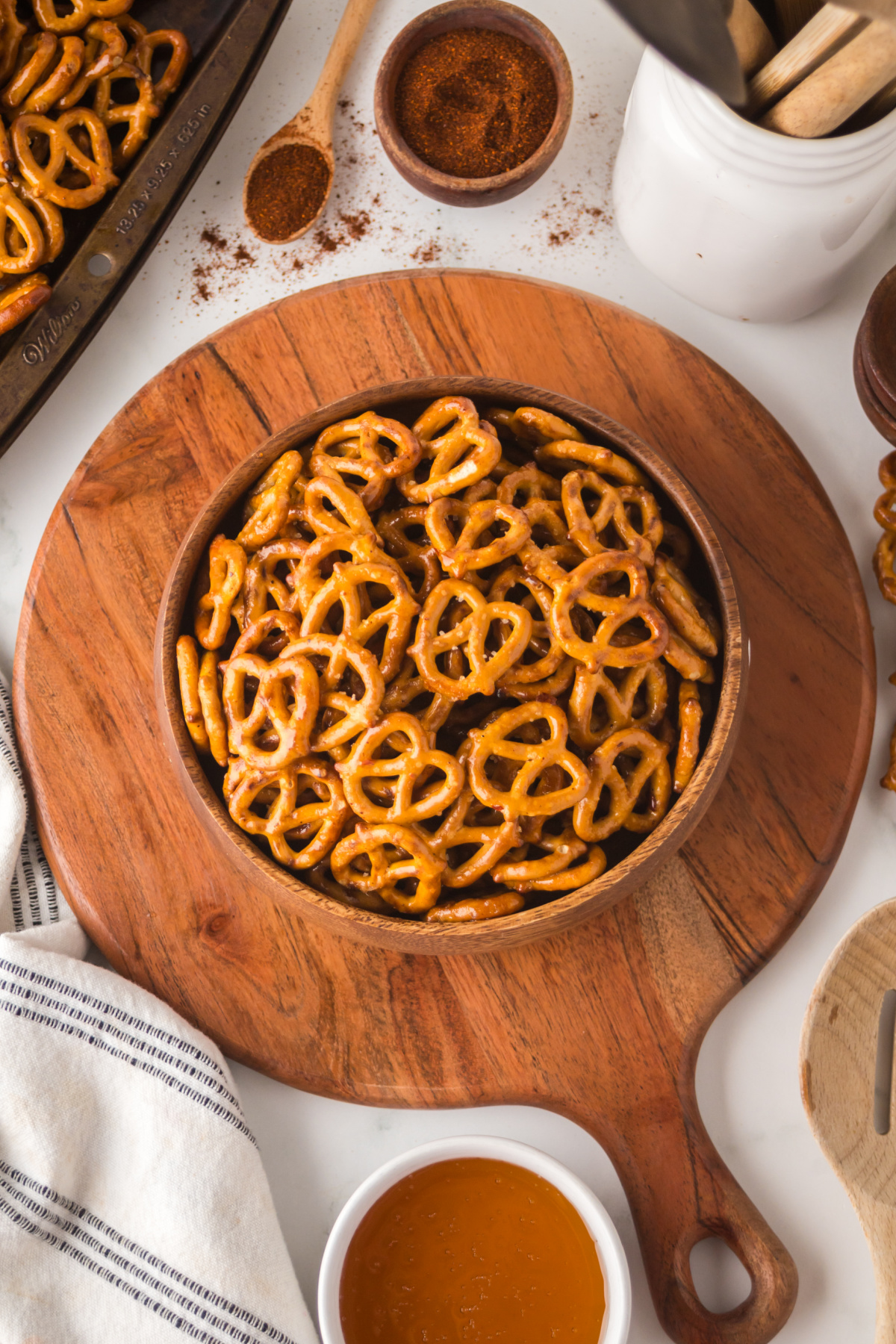 A wooden bowl of pretzels on a table.