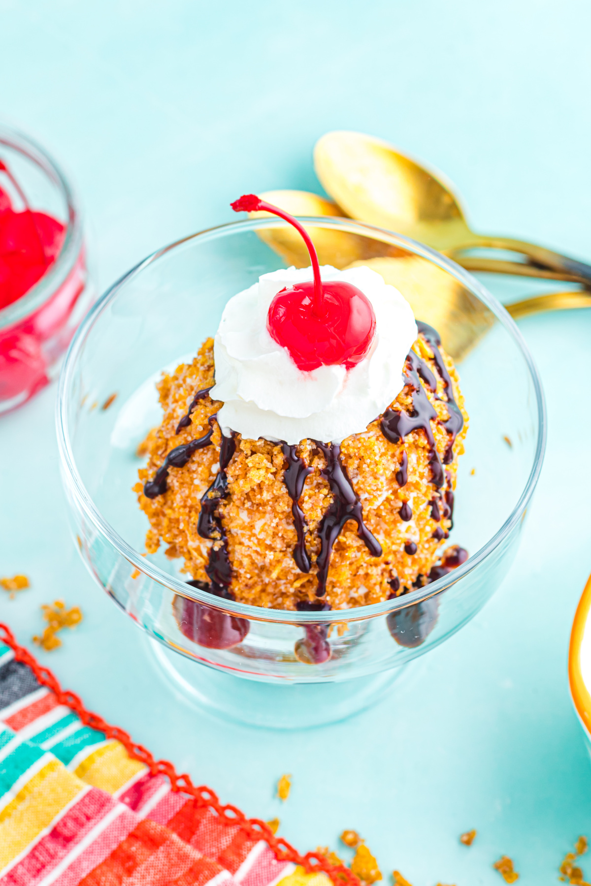 The coated ice cream drizzled with chocolate syrup and whipped cream.