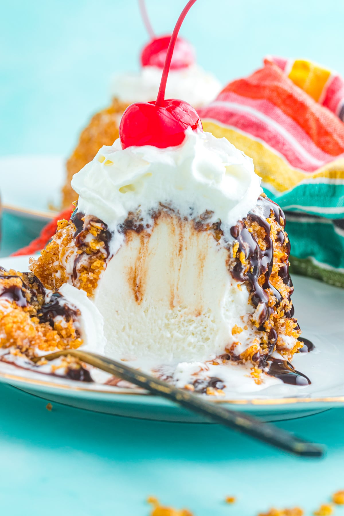 A spoon taking some of the fried ice cream out of the plate.