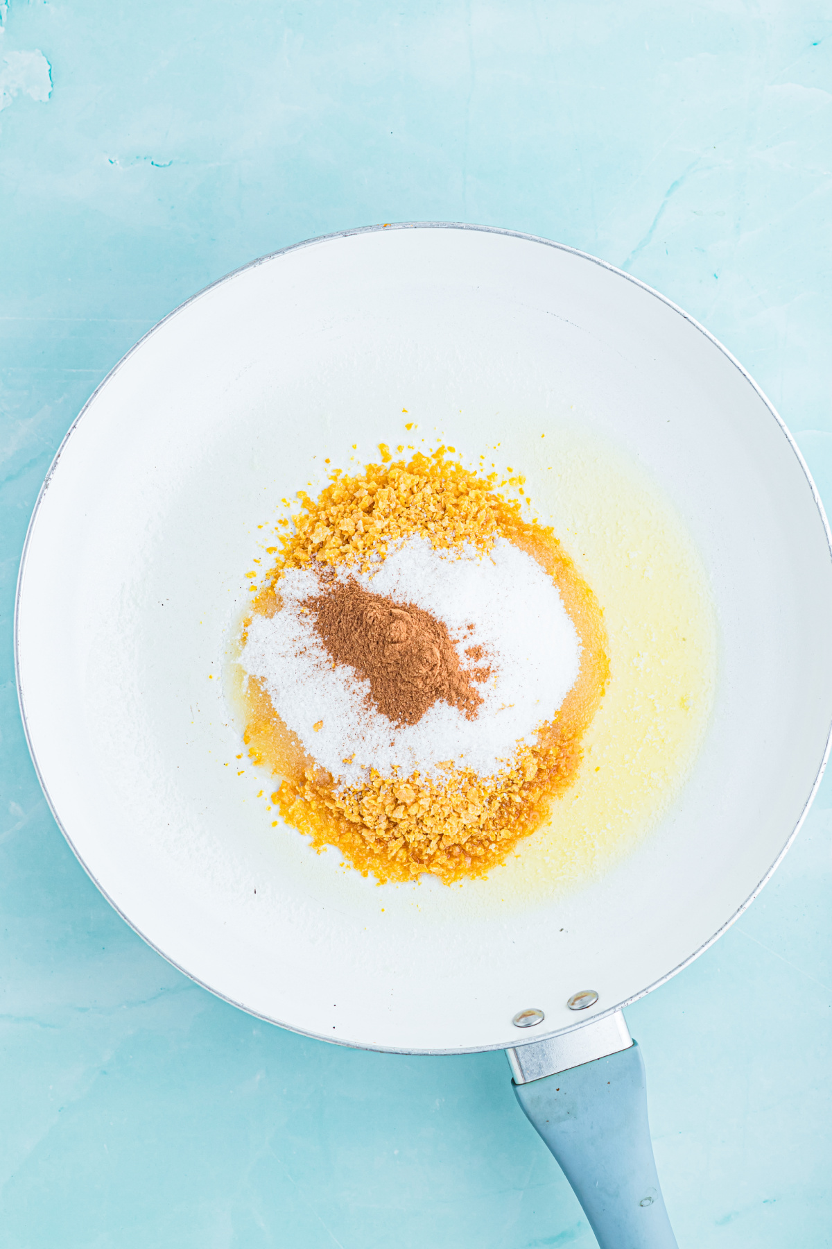 Melted butter, cornflakes, cinnamon, and sugar in a skillet.