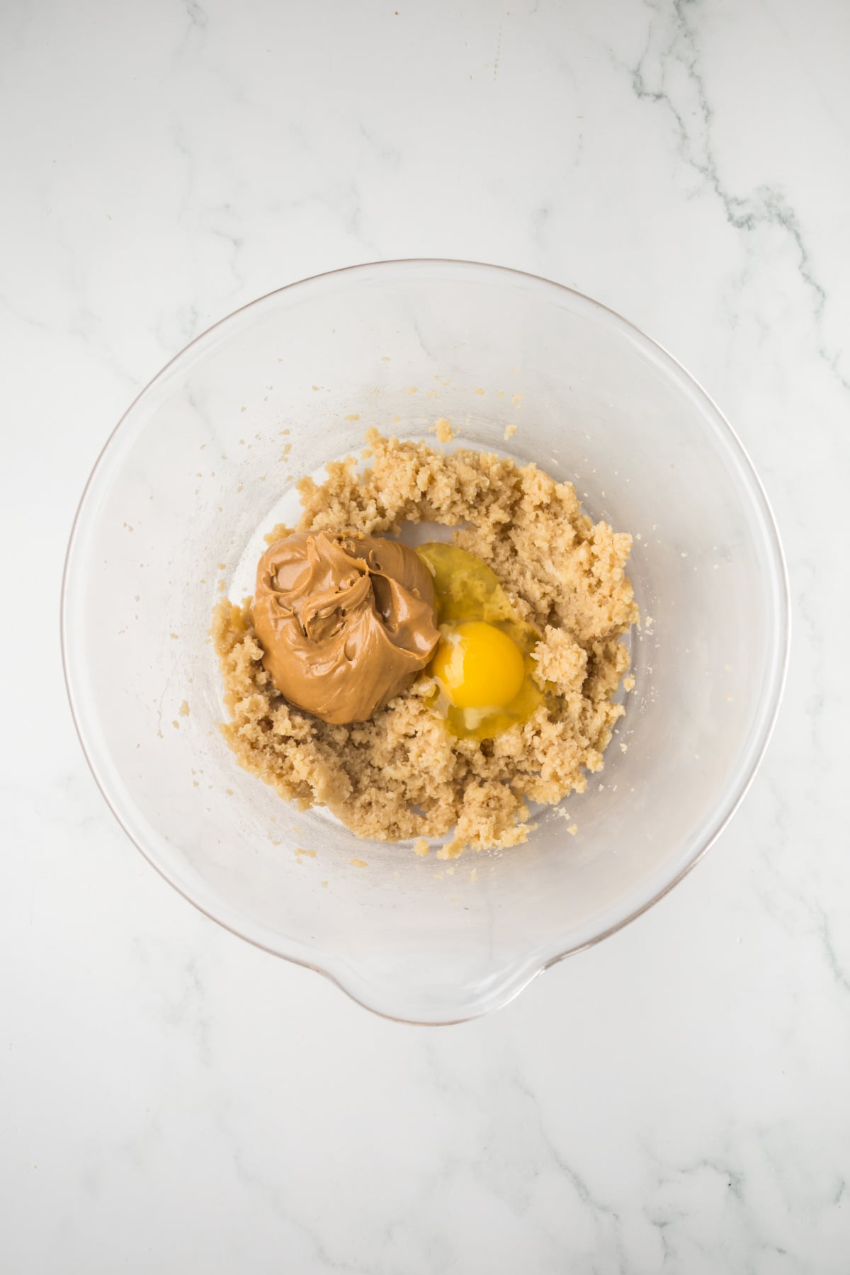 mixing butter sugar, egg and peanut butter for cobbler topping in bowl